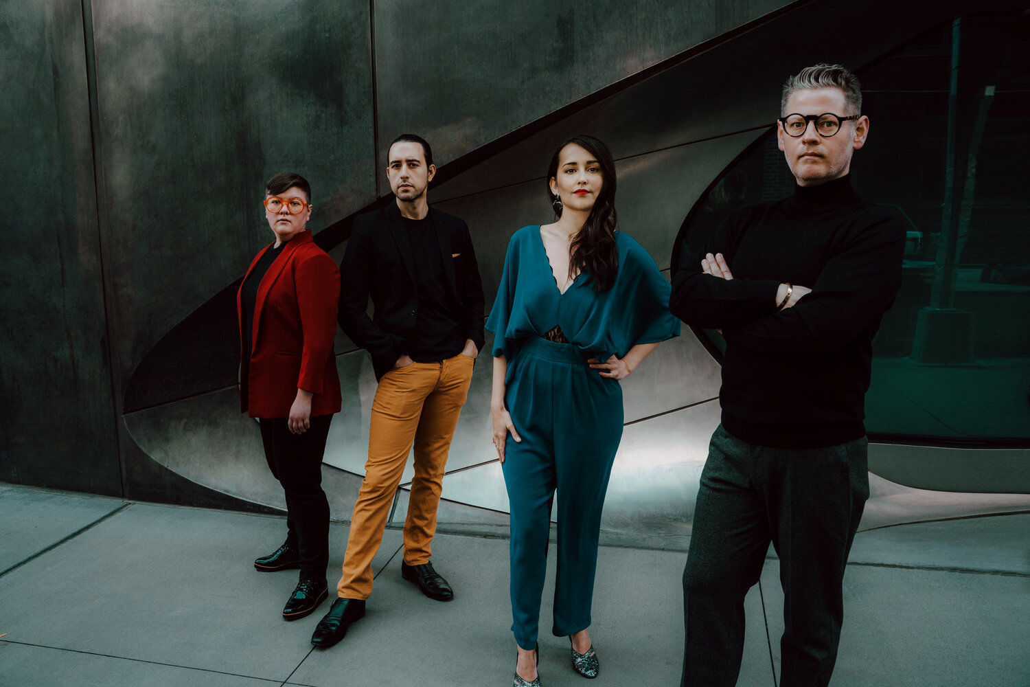 The four members of the Catalyst Quartet stand at various angles against a metallic backdrop, looking into the camera.